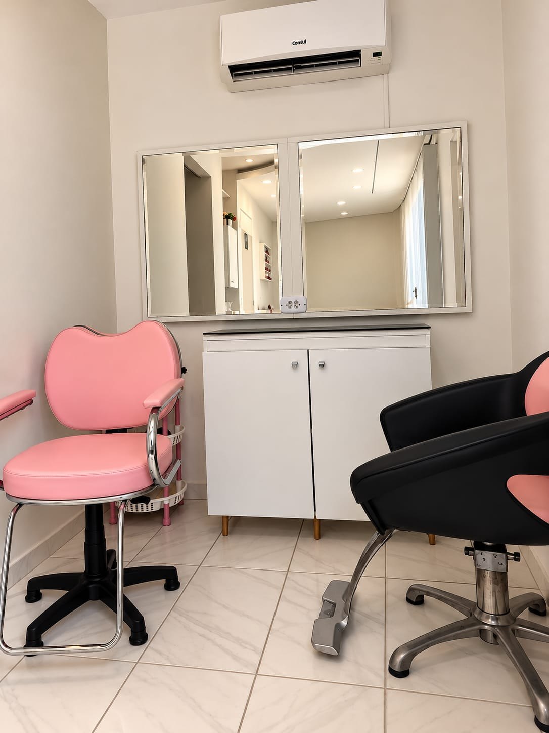 Espaço de atendimento do Salão Autoestima com poltronas rosa e espelhos