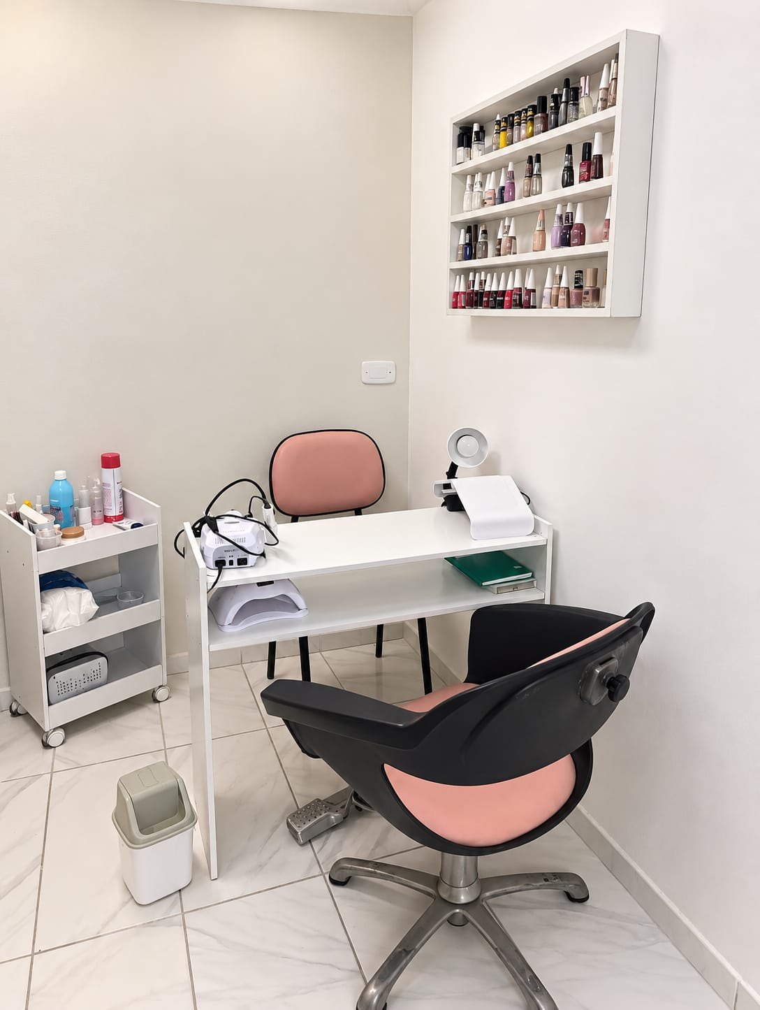 Espaço preparado para atendimento de unhas com mesa e produtos organizados